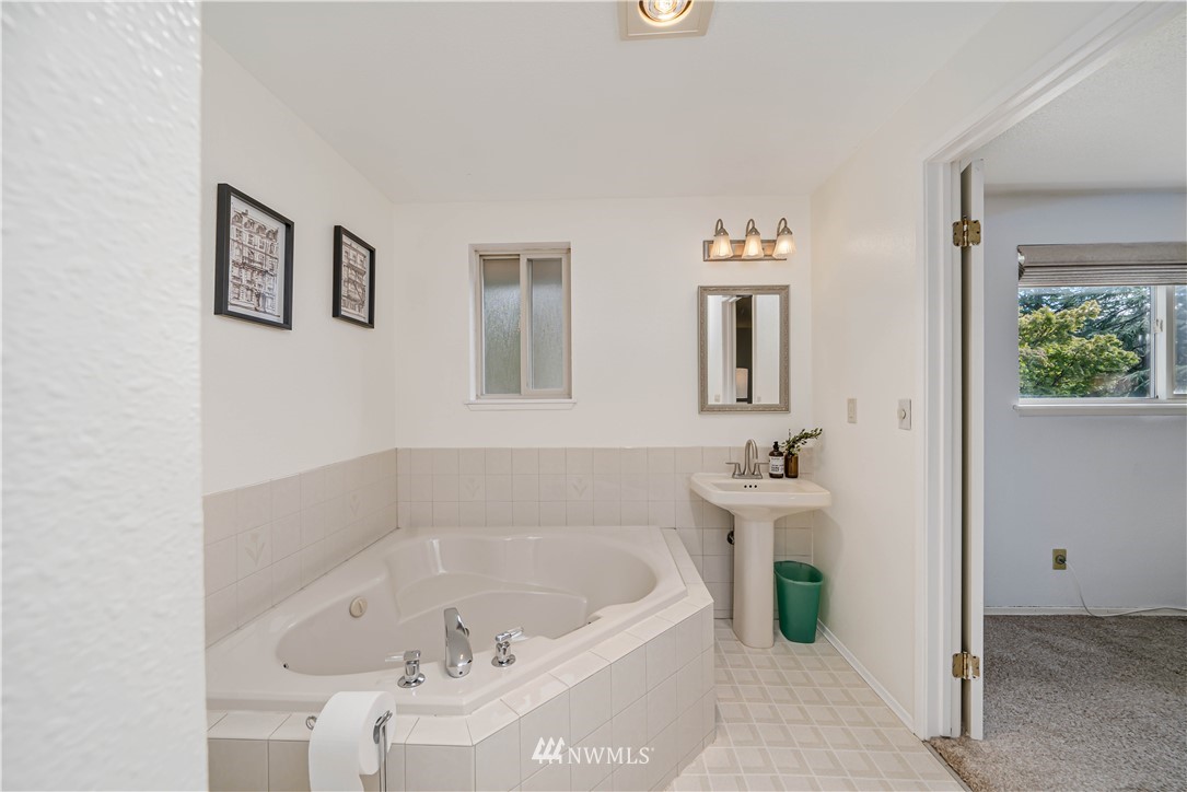 18003 Rhodes Lake Road East Bonney Lake, WA 98391 - Photo 12 of 40 a bathroom with a bathtub and a window