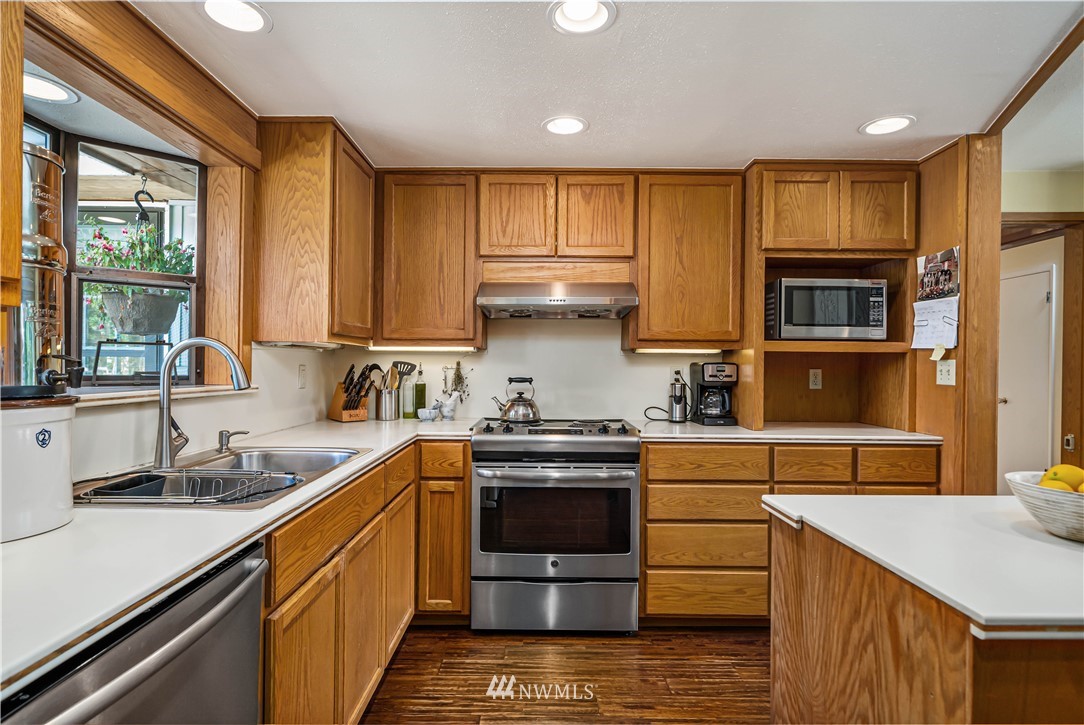 18003 Rhodes Lake Road East Bonney Lake, WA 98391 - Photo 6 of 40 a kitchen with stainless steel appliances granite countertop a sink stove and refrigerator