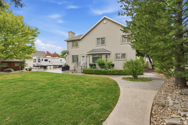 1888 East Cobblestone Road Springville, UT 84663 - Photo 39 of 44 Expansive rear yard featuring a manicured lawn, concrete pathway, and mature trees