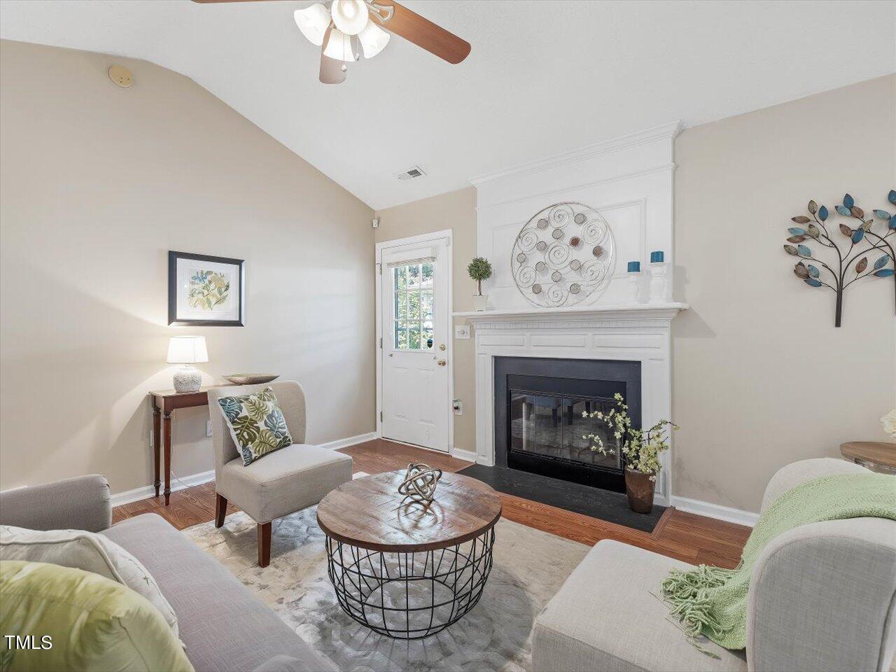 4509 Dolwick Drive Durham, NC 27713 - Photo 6 of 31 a living room with furniture a fireplace and a chandelier