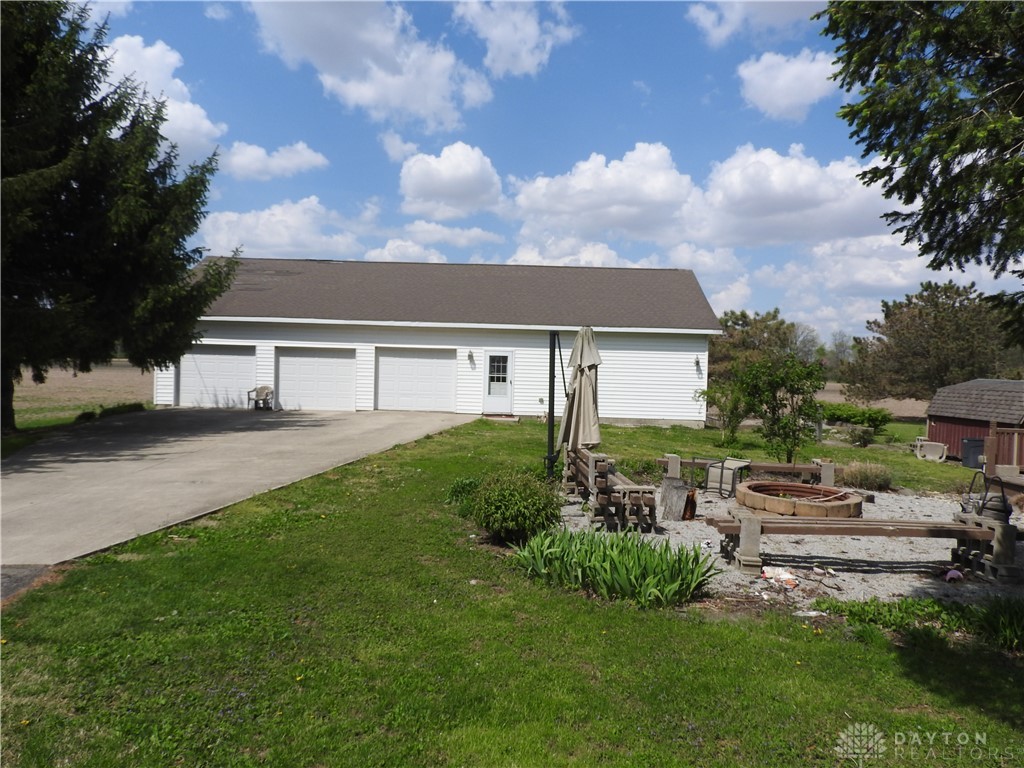 2105 East Loy Road Piqua, OH 45356 - Photo 6 of 26 This spacious garage offers ample storage and workshop potential, complemented by a charming outdoor fire pit.