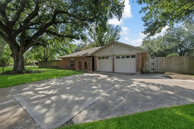 a view of a house with a yard and large tree