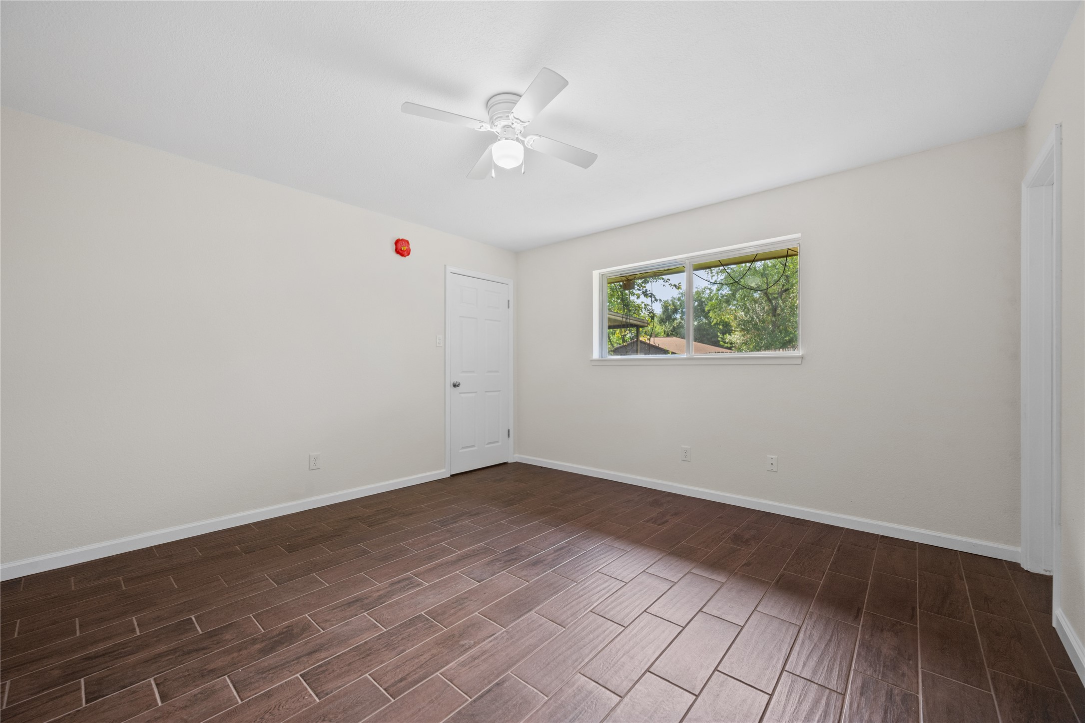 3930 Tumbleweed Lane Baytown, TX 77521 - Photo 11 of 23 wooden floor in an empty room with a window
