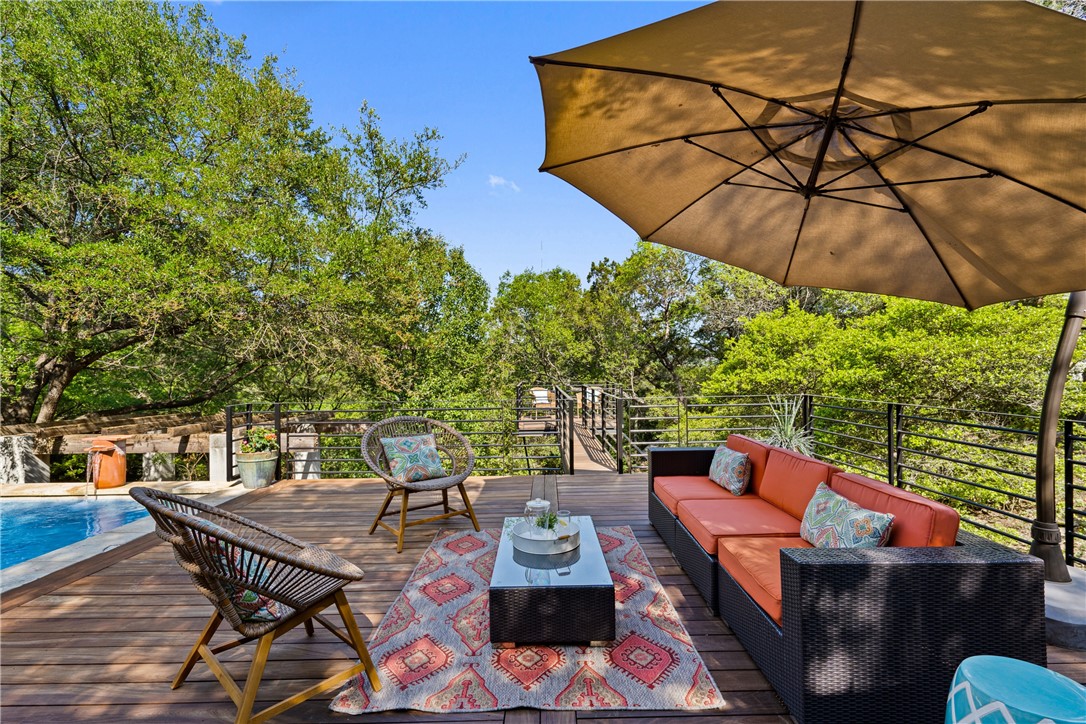 1402 Wild Basin Ledge Austin, TX 78746 - Photo 1 of 1 an outdoor sitting area with furniture and umbrella