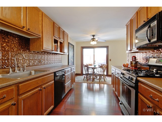 12 Winrock Road Montgomery, IL 60538 - Photo 5 of 19 a kitchen with stainless steel appliances granite countertop a stove top oven a sink dishwasher and cabinets with wooden floor