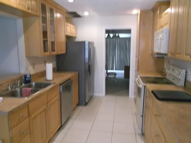 a kitchen with stainless steel appliances granite countertop a refrigerator and a sink