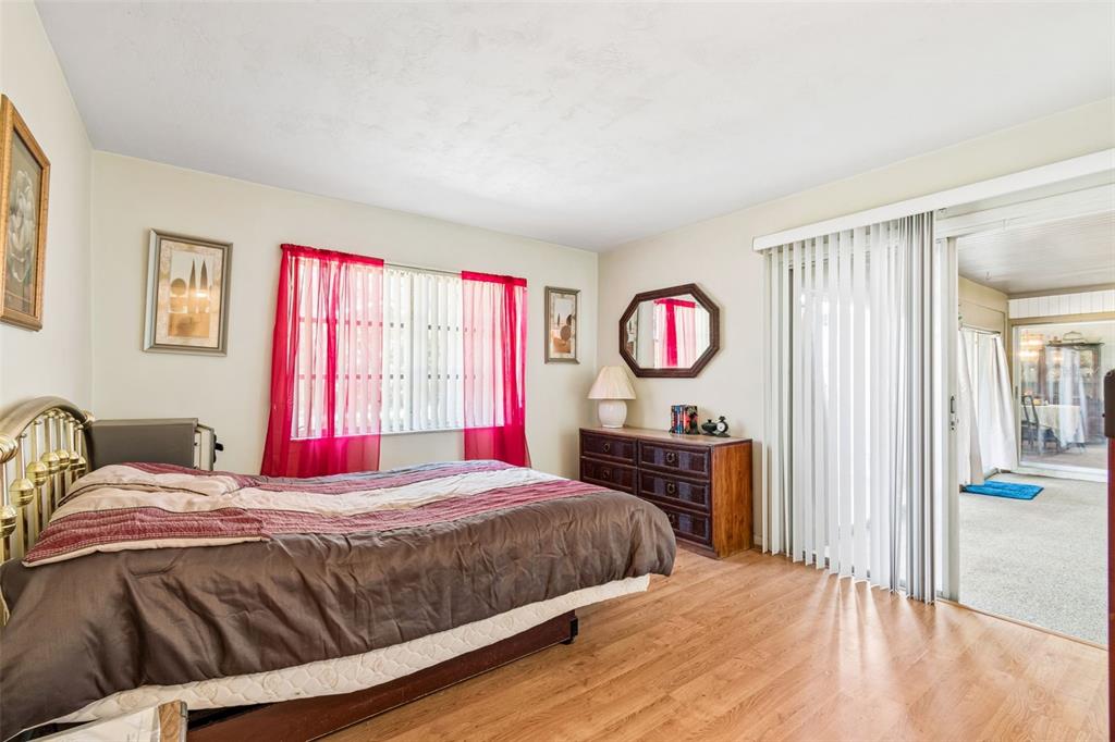 2059 Waterfall Drive Spring Hill, FL 34608 - Photo 16 of 26 a bedroom with a bed and dresser with wooden floor