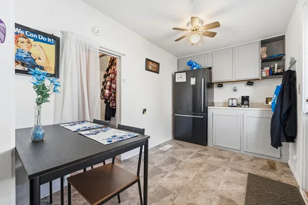 a kitchen with stainless steel appliances granite countertop a refrigerator a stove a sink dishwasher and a dining table with wooden floor