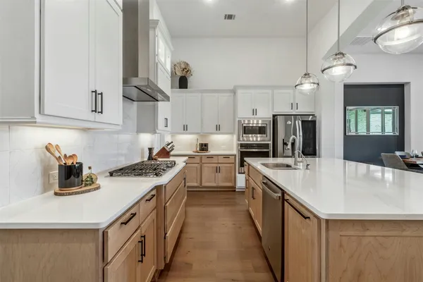 a kitchen with stove a sink and cabinets
