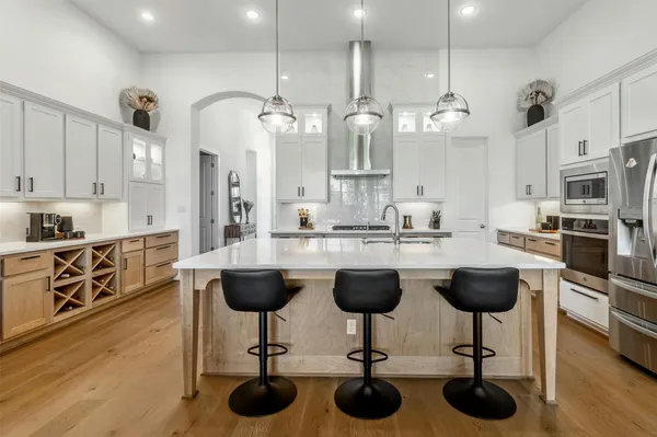a kitchen with stainless steel appliances granite countertop a stove a sink a center island and cabinets