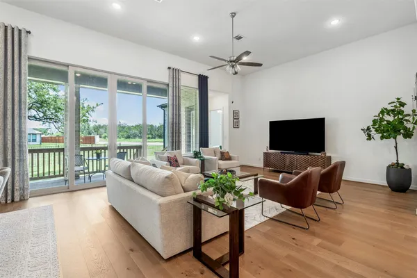 a living room with furniture a flat screen tv and a large window