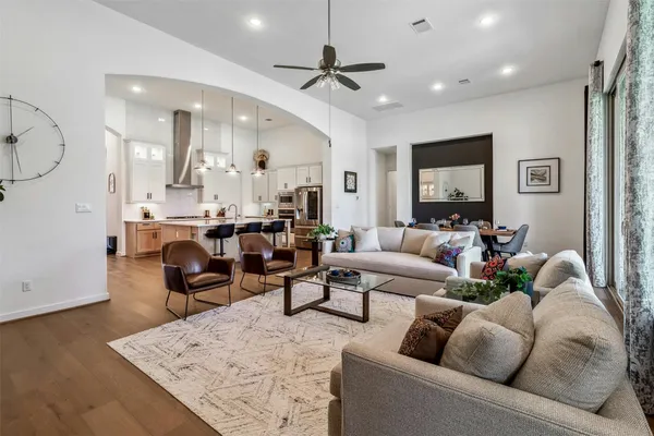 a living room with furniture kitchen view and a chandelier