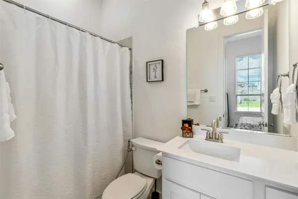 a bathroom with a sink vanity mirror and toilet