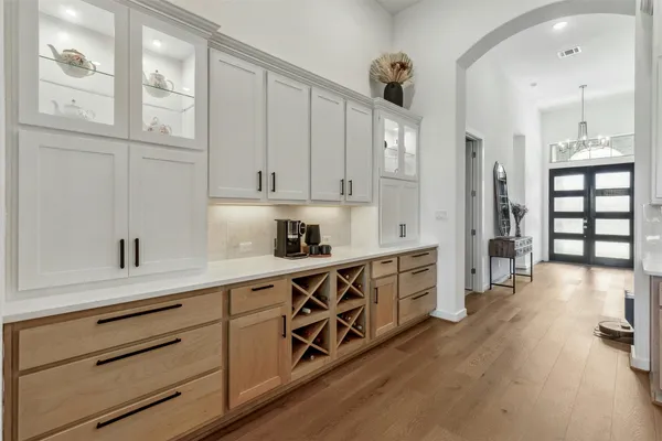 a kitchen with stainless steel appliances white cabinets and wooden floors