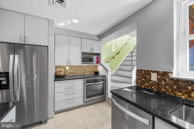 a kitchen with granite countertop a refrigerator and a sink