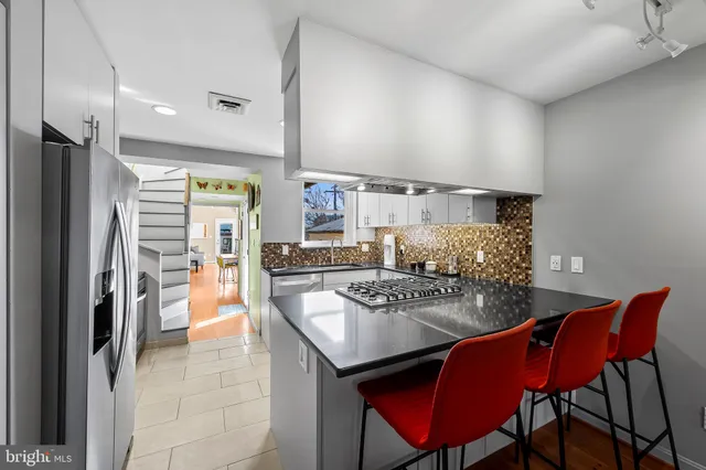 a kitchen with stainless steel appliances granite countertop a stove a refrigerator and a dining table