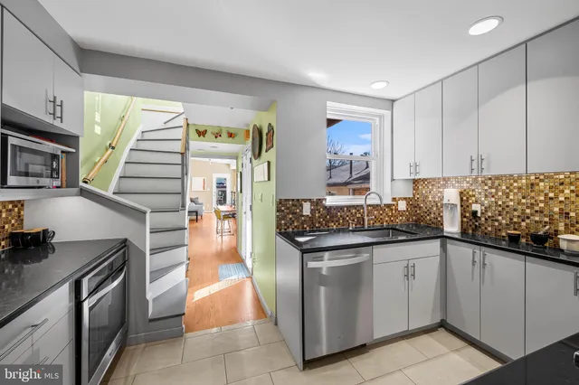 a kitchen with granite countertop a sink and a stove