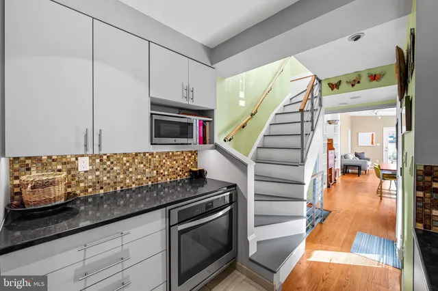a kitchen with granite countertop a stove a sink and a microwave