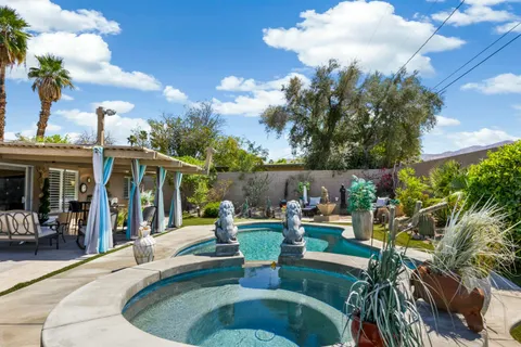a view of a house with backyard sitting area and garden