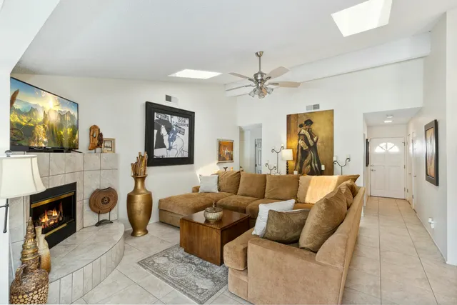 a living room with furniture a flat screen tv and a fireplace