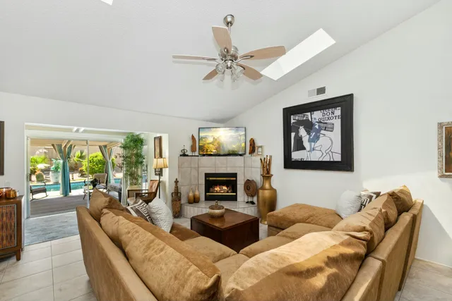 a living room with furniture a fireplace and a large window