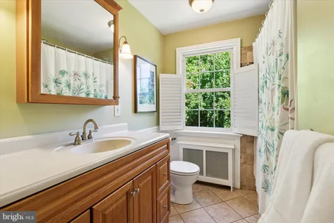 a bathroom with a sink a toilet and a window