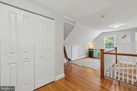 a view of a hallway with wooden floor and staircase