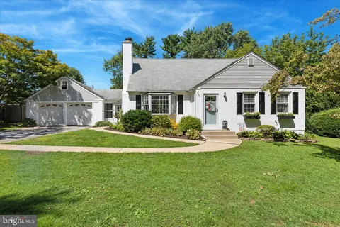 a view of a house with a big yard plants and large trees