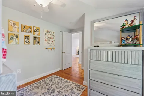 a view of a hallway with wooden floor and a chandelier