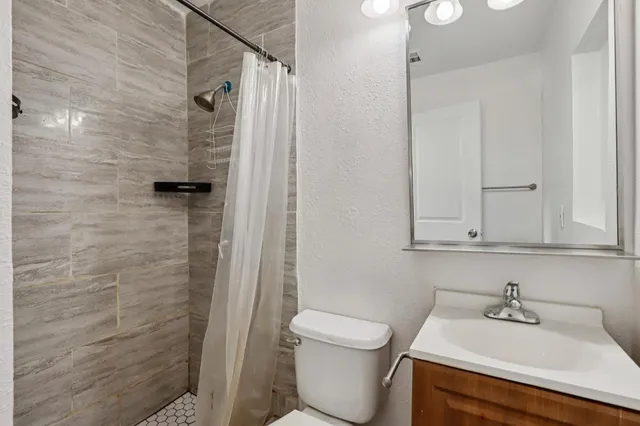 a bathroom with a sink a toilet and shower