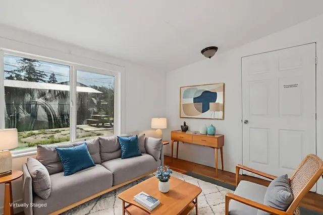 a living room with furniture and a floor to ceiling window