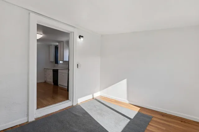 an empty room with wooden floor and a floor to ceiling window