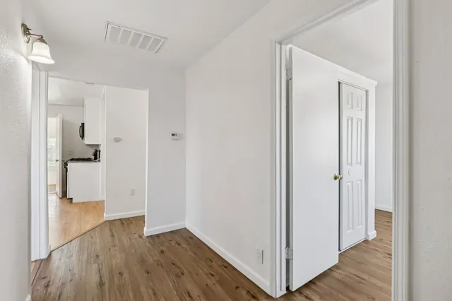 a view of a hallway with wooden floor