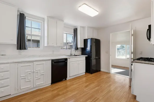 a kitchen with granite countertop a refrigerator stove top oven and sink