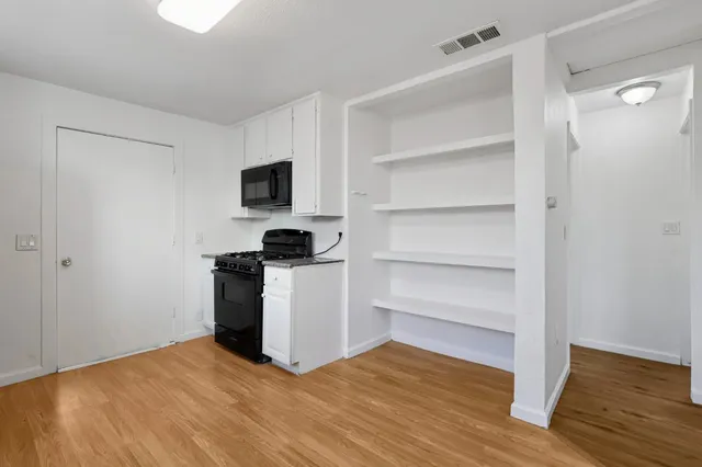 a view of a room with wooden floor and a sink