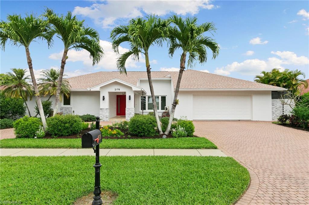 2178 Pinewoods Circle, Unit 25 Naples, FL 34105 - Photo 1 of 45 a front view of house with yard and green space
