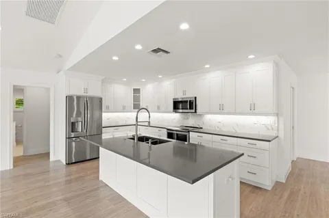 a kitchen with stainless steel appliances granite countertop a sink a stove and a refrigerator