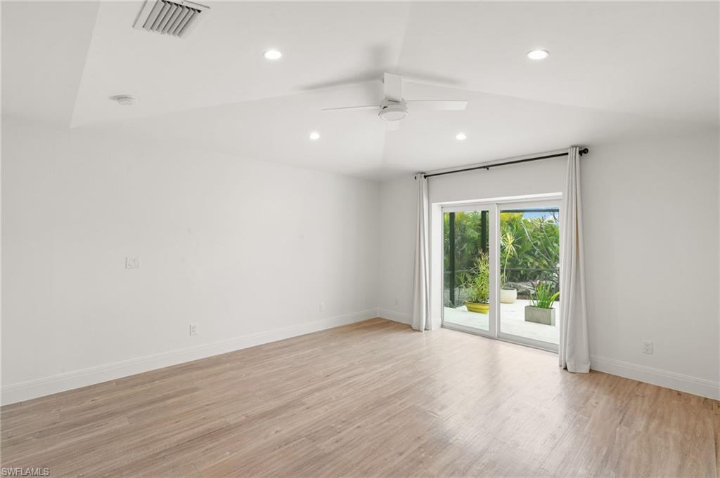 2178 Pinewoods Circle, Unit 25 Naples, FL 34105 - Photo 20 of 45 an empty room with wooden floor and windows