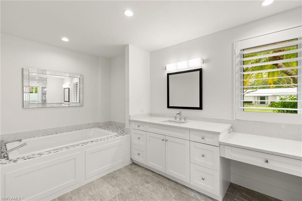 2178 Pinewoods Circle, Unit 25 Naples, FL 34105 - Photo 23 of 45 a spacious bathroom with 2 sink tub and a mirror