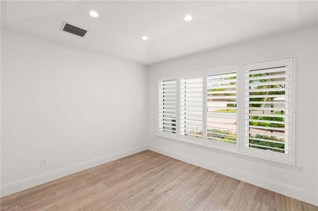 2178 Pinewoods Circle, Unit 25 Naples, FL 34105 - Photo 26 of 45 an empty room with wooden floor and windows