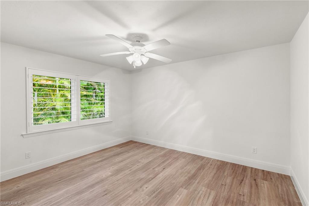 2178 Pinewoods Circle, Unit 25 Naples, FL 34105 - Photo 27 of 45 an empty room with wooden floor and windows