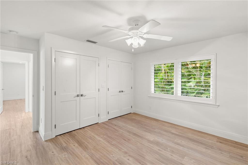 2178 Pinewoods Circle, Unit 25 Naples, FL 34105 - Photo 28 of 45 a view of an empty room with wooden floor and a window