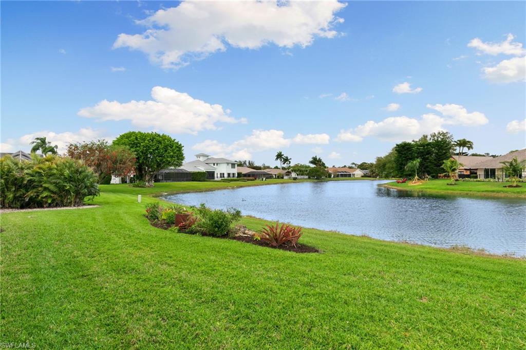 2178 Pinewoods Circle, Unit 25 Naples, FL 34105 - Photo 40 of 45 a view of a lake with houses in the back