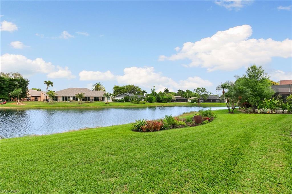2178 Pinewoods Circle, Unit 25 Naples, FL 34105 - Photo 42 of 45 a view of a lake with houses in the back