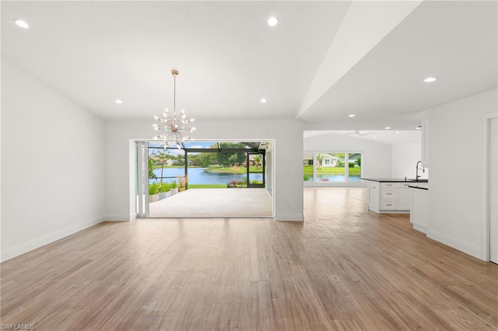 2178 Pinewoods Circle, Unit 25 Naples, FL 34105 - Photo 6 of 45 a view of an empty room with a window and wooden floor