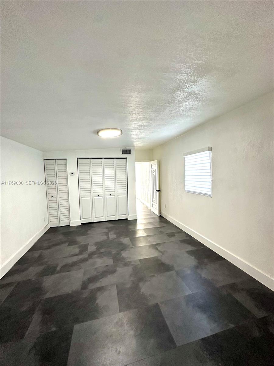 1960 West 63rd Street, Unit EFFICIENCY Hialeah, FL 33012 - Photo 8 of 12 an empty room with windows and pillars in it