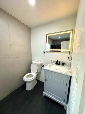 a bathroom with a toilet sink and mirror