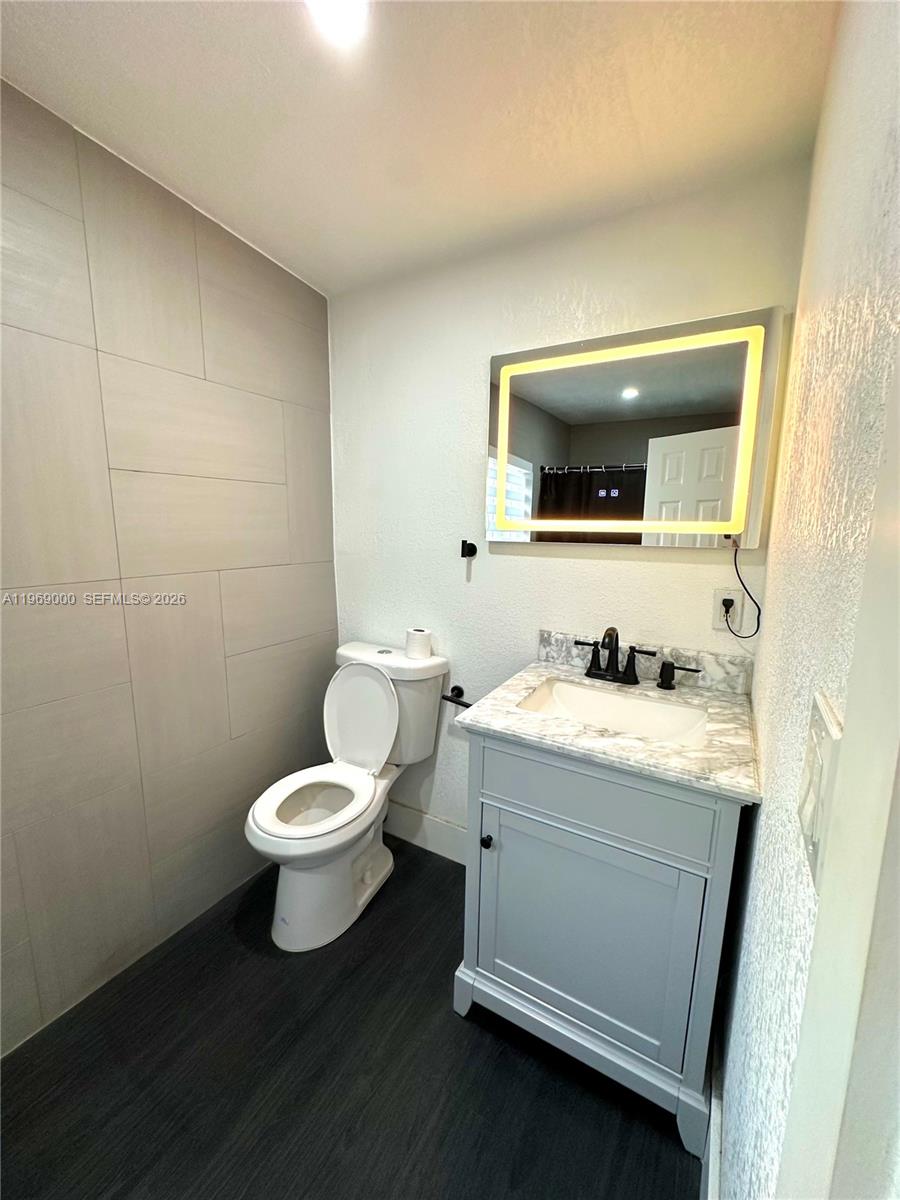 1960 West 63rd Street, Unit EFFICIENCY Hialeah, FL 33012 - Photo 9 of 12 a bathroom with a toilet sink and mirror