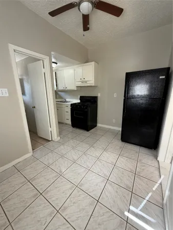 a kitchen with granite countertop a refrigerator and cabinets