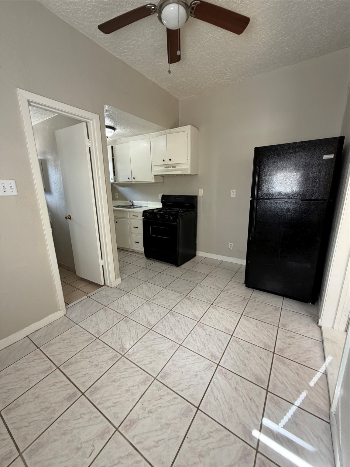 1611 Common Street, Unit 1 Houston, TX 77009 - Photo 6 of 7 a kitchen with granite countertop a refrigerator and cabinets